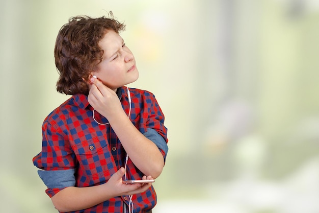 Attracive kid is listening music with headphones