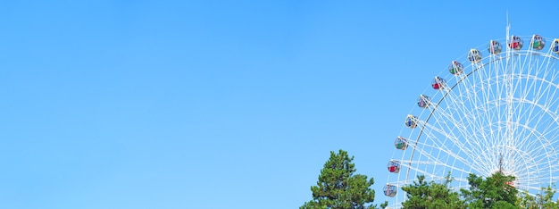 Attraction Ferris wheel on the background of blue sky, wide banner