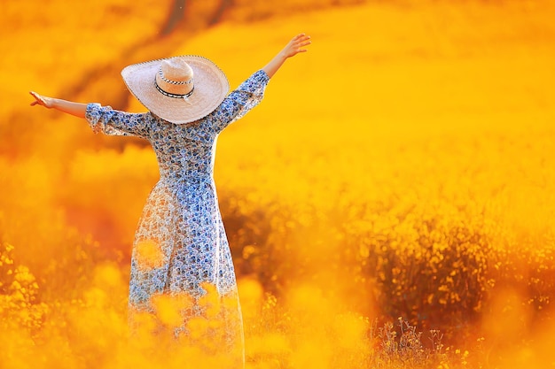 Attractive active beautiful female, freedom happy view from the back, in a field of flowers