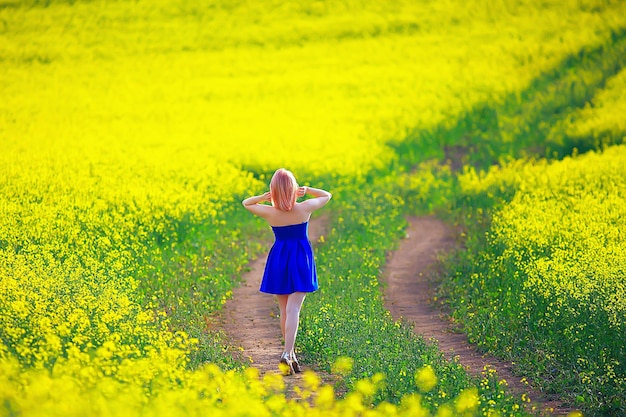 attractive active beautiful female, freedom happy view from the back, in a field of flowers