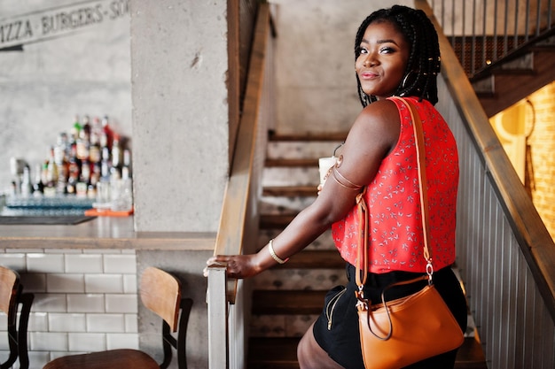 Привлекательная африканская американка позировала в кафе на лестнице