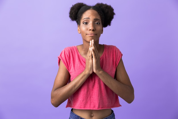 attractive african american woman keeping palms together for pray, isolated