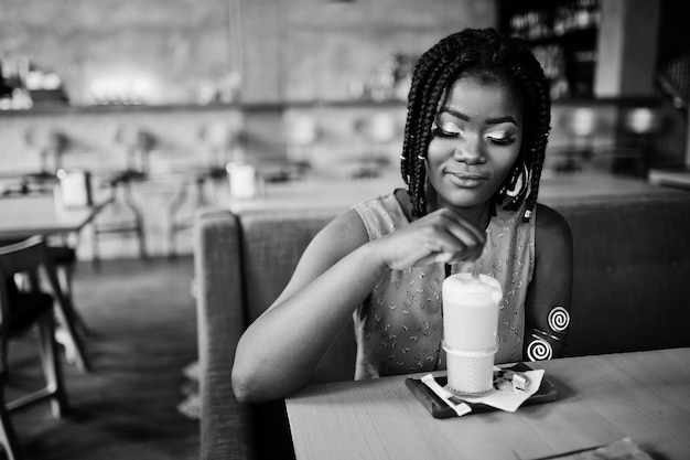 Attractive african american woman sitting at table on cafe with latte