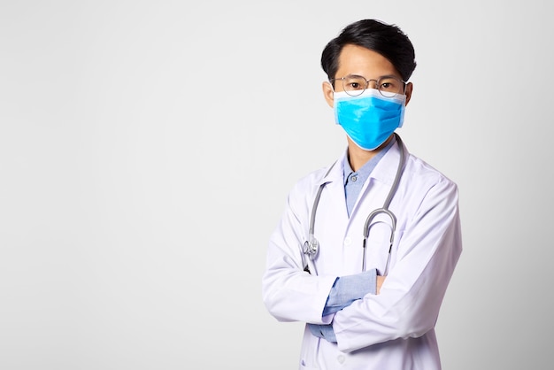 Attractive asia man doctor wearing surgical mask and posing