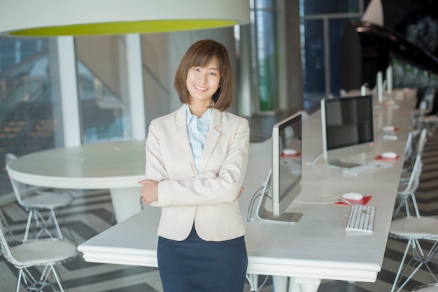 Attractive asian business woman smiling in workplace