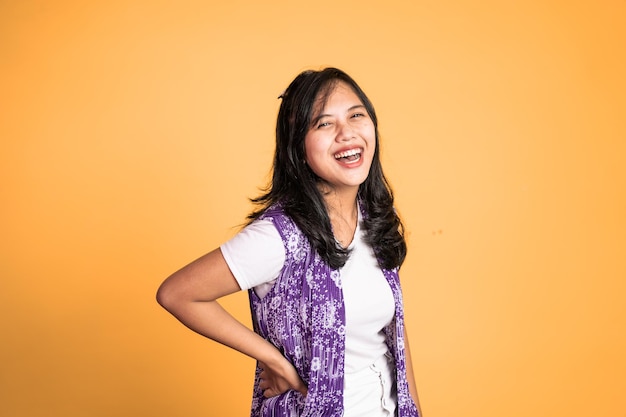 Attractive asian ethnicity female looking at camera smiling with fun gesture on isolated background