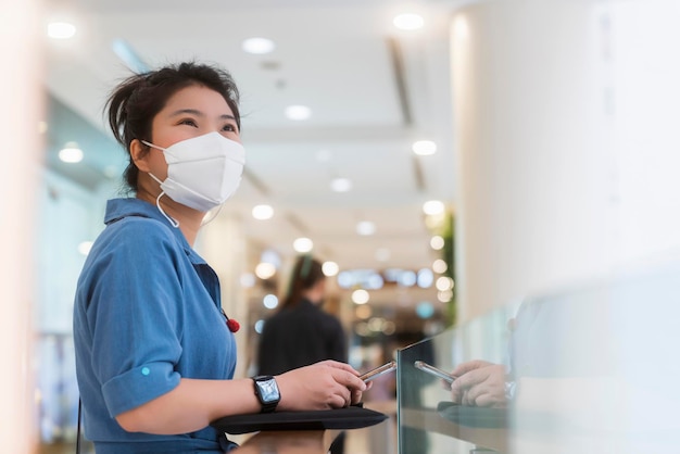 Attractive asian female woman casual cloth wearing face mask protection standing in mall department store new normal lifestyle healthcare concept