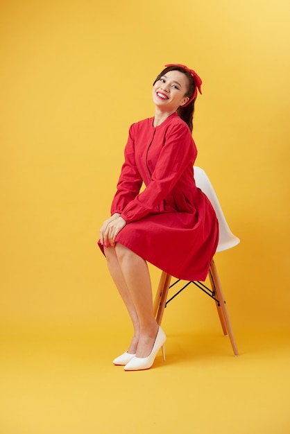 Attractive Asian girl sitting on white modern chair and relax at home