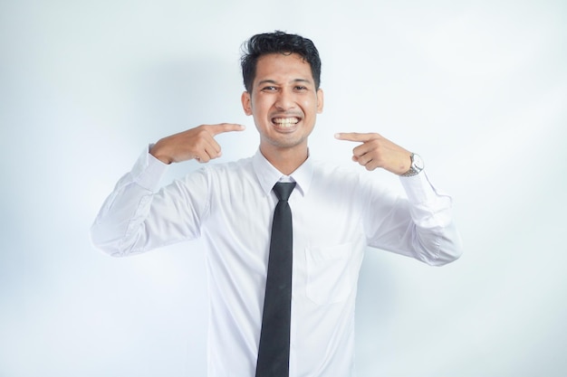 Photo attractive asian man big smiling while pointing finger to his teeth