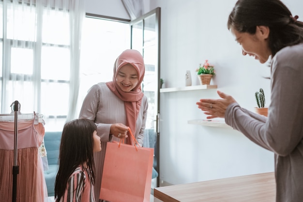 Привлекательные азиатские мусульманские мать и дочь делают покупки в небольшом бутике