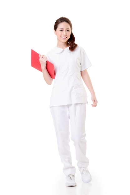 Attractive Asian nurse, woman portrait against white wall.