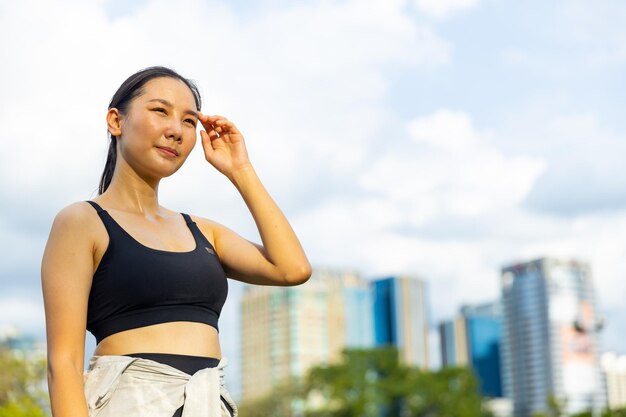 Photo attractive asian woman in sportswear jogging exercise at public park in summer morning healthy girl athlete enjoy outdoor activity lifestyle sport training fitness running workout in the city