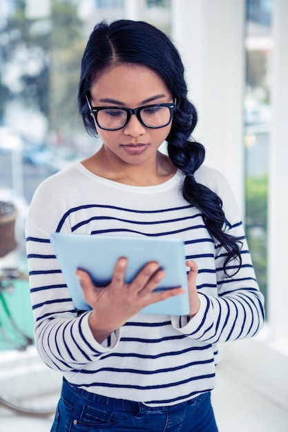 Attractive Asian woman using tablet standing in office