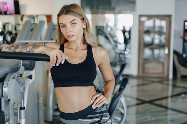 Attractive athletic girl standing near gym equipment. healthy lifestyle.