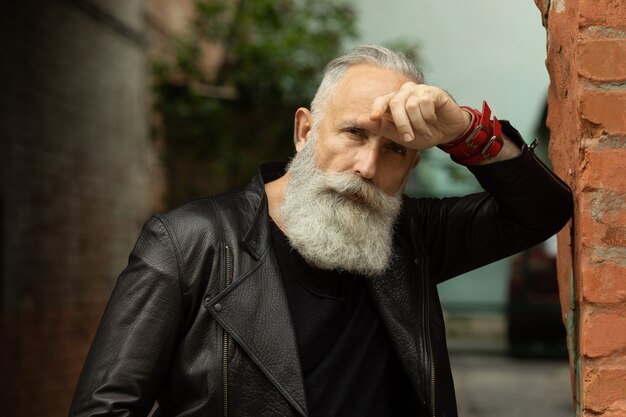 Foto uomo barbuto attraente del modello senior nel contesto urbano.