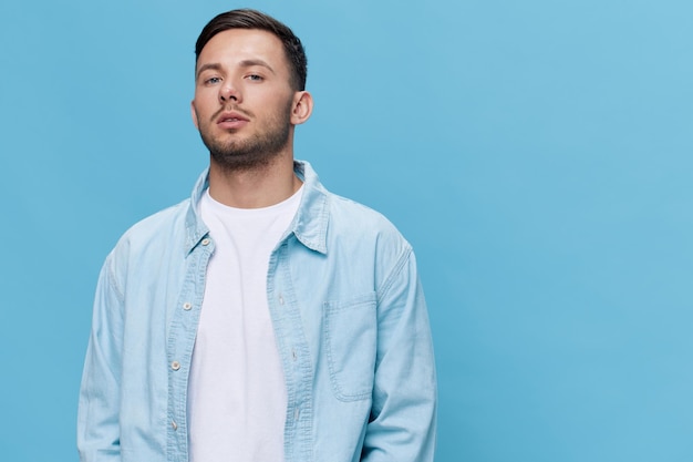 Attractive beautiful confident tanned handsome man in casual\
basic tshirt posing isolated on blue studio background copy space\
banner mockup people emotions lifestyle concept cool fashion\
offer