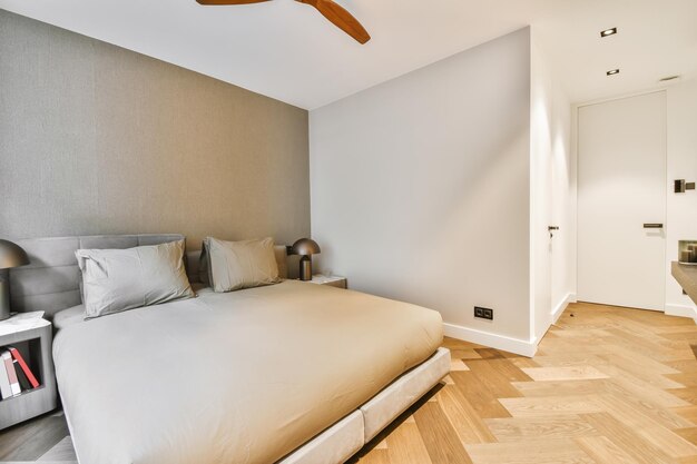 Привлекательная спальня в минималистском стиле с мягкой двуспальной кроватью, покрытой
