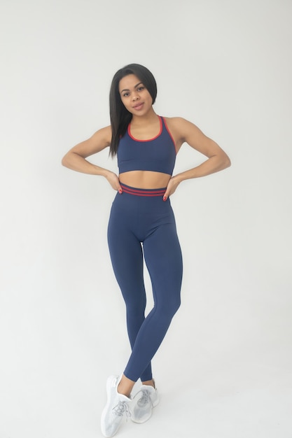 Attractive black african american woman in colour leggings and top fitness outfit
