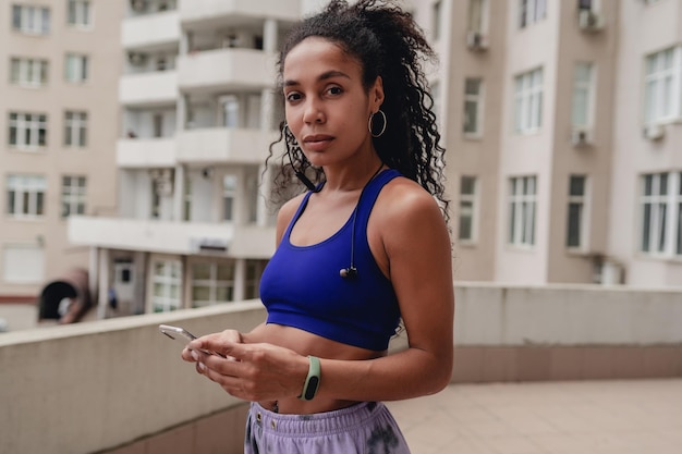 Attractive black african american woman in sport fitness outfit on rooftop making work out