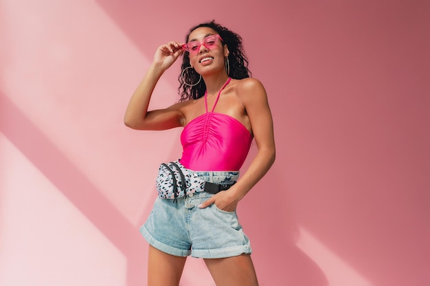 Attractive black african american woman in stylish outfit on pink background