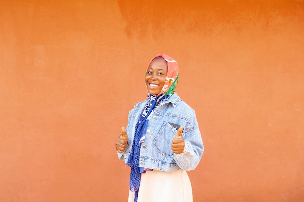 Attractive black girl holding thumbs up looking at camera