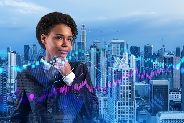 Attractive black woman trader and stock market analyst in suit\
dreaming about market behavior and forecast in crisis women in\
business concept forex chart kuala lumpur double exposure