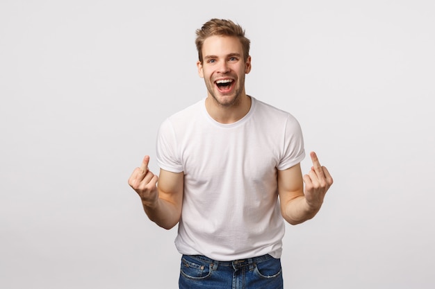 Attractive blond bearded man in white T-shirt showing middle fingers