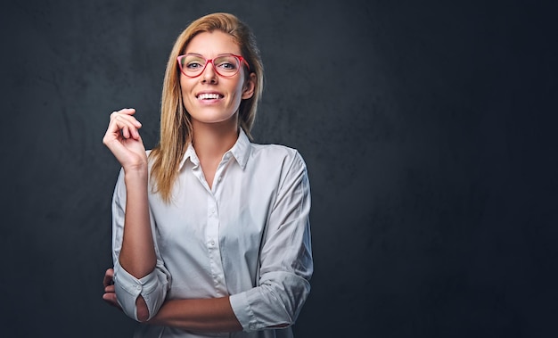 Attractive blond business woman in a white shirt over grey background.