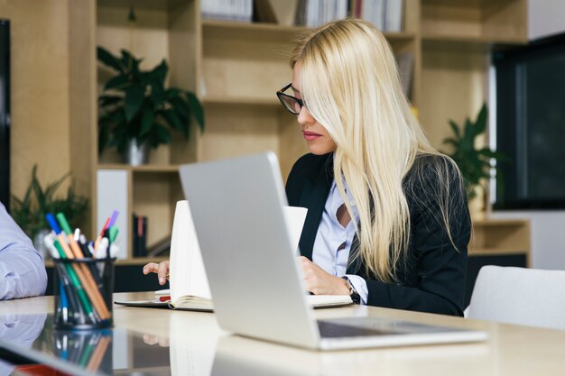 近代的なオフィスで働く魅力的な金髪の女性実業家