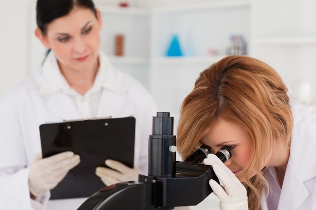 Attractive blond-haired scientist and her assistant conducting an experiment