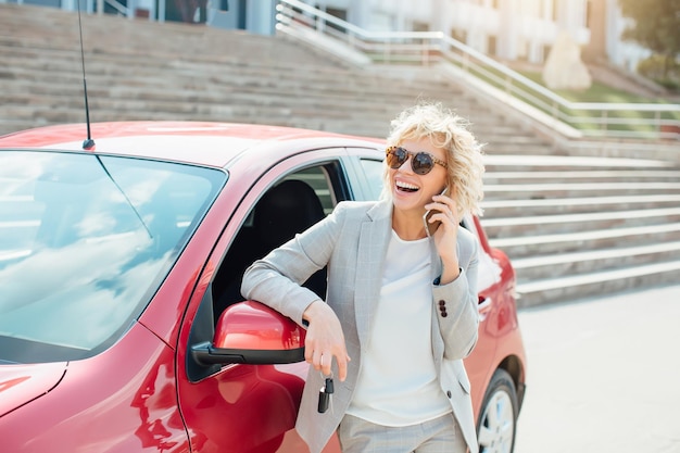 Bionda attraente in un'auto che mostra le chiavi