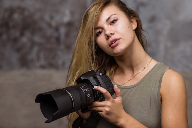 Attractive blonde girl with DSLR camera