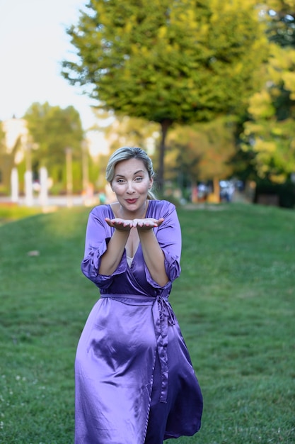 Attraente bionda si sta godendo la meditazione nel parco pubblico