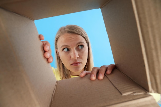 An attractive blonde looks into a cardboard box