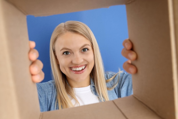 An attractive blonde looks into a cardboard box