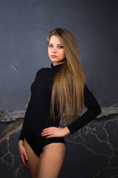 Attractive blonde woman in a black underwear at studio