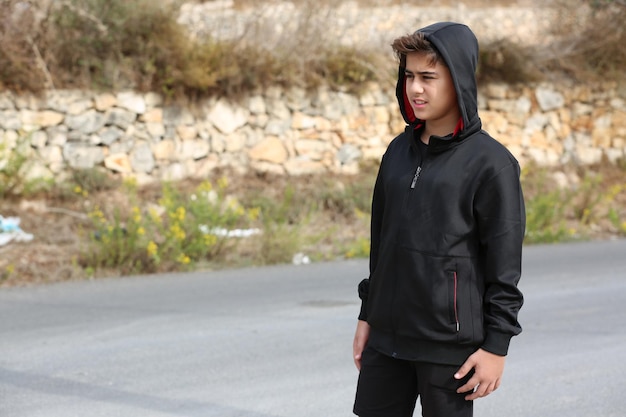 Attractive boy wearing black sport clothing  walking in an ancient street Free Photo