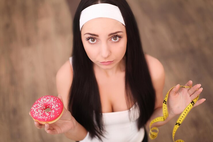 Attractive brunette sexy woman eating tasty donut Outdoors lifestyle portrait of pretty girl