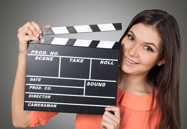 Attractive brunette young woman with movie clip on  background