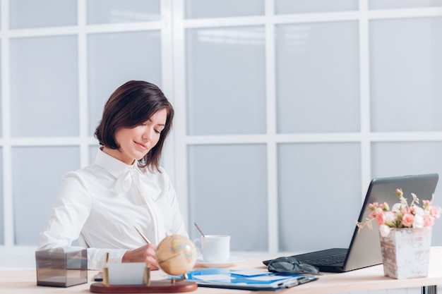 Attractive business woman working at the desk in the office