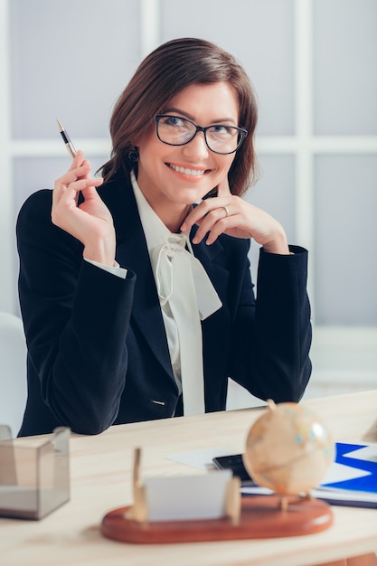 Foto attraente donna d'affari che lavora alla scrivania in ufficio