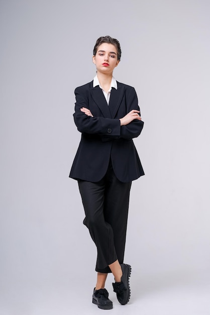 Attractive business young woman posing in business black suit with short