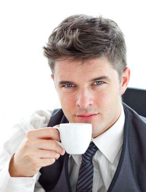 Attractive businessman drinking coffee in the office