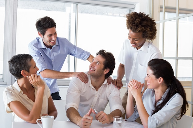 Attractive businessman praising coworker