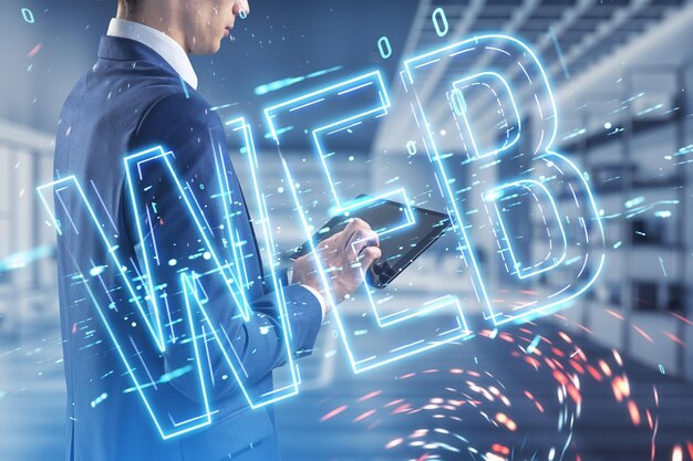 Attractive businessman using tablet with glowing linear web text hologram on blurry office interior background Digital nft technology and future concept Double exposure