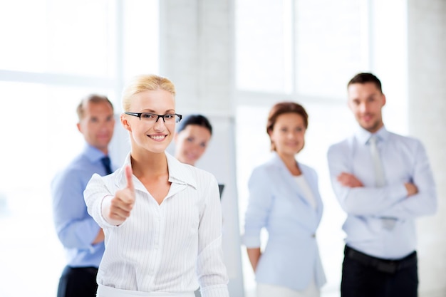 attractive businesswoman in office showign thumbs up