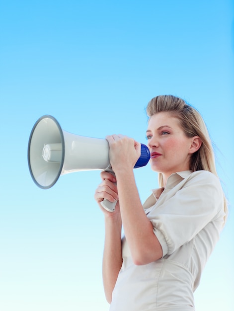 Attractive businesswoman shouting in a megaphone