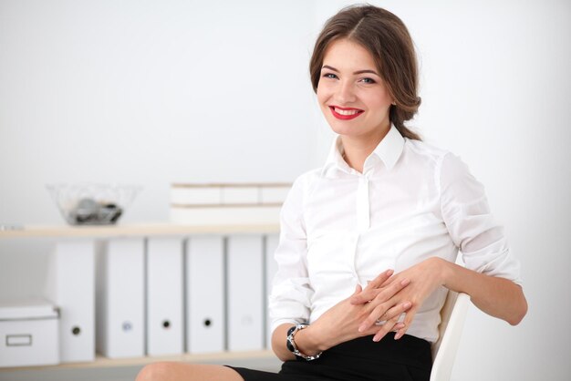 Attractive businesswoman sitting on chair in the office