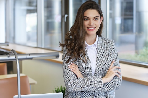 Attractive businesswoman standing near desk in the office.