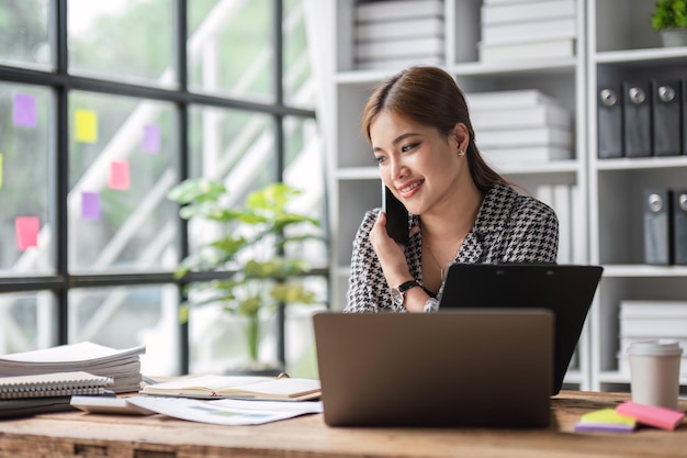 Attractive businesswoman uses calculator to do finance mathematics on wooden table in office and